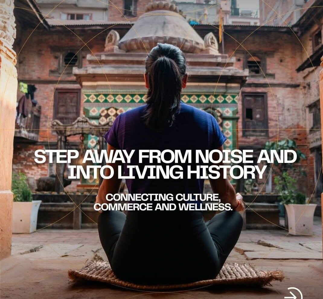 Practitioner seated facing a carved Newari temple in a Patan courtyard